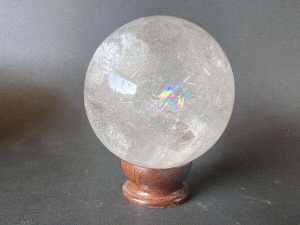 A Quartz Spheres ball on a clear wooden stand.