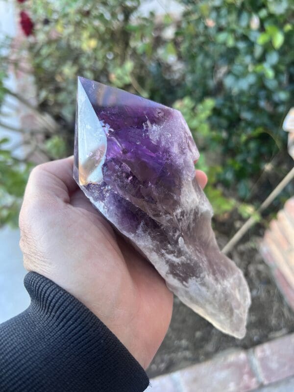 A person holding a Large Amethyst Dragon's Tooth Scepter From Bahia, Brazil 724 grams, in their hand.