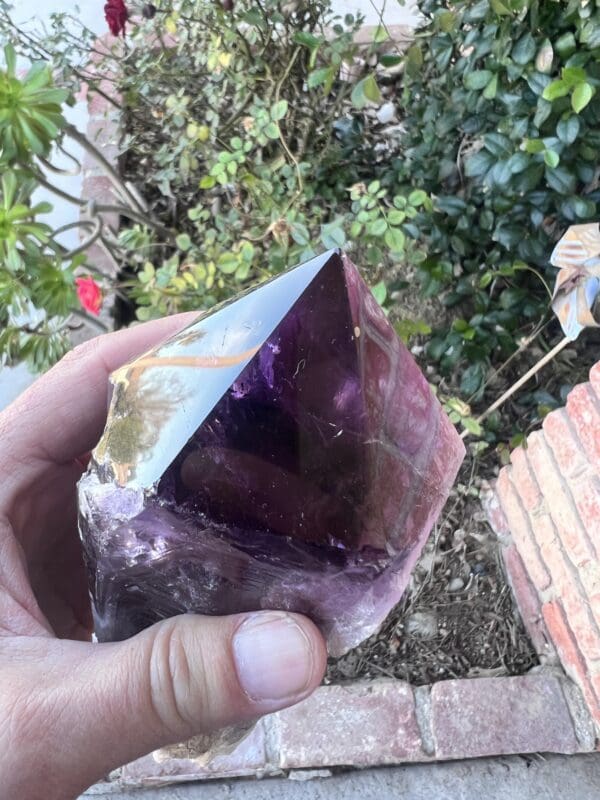 A person holding up a Large Amethyst Dragon's Tooth Scepter From Bahia, Brazil 902 grams.