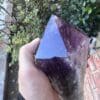 A person holding a Large Amethyst Dragon’s Tooth Scepter From Bahia, Brazil 840 grams.