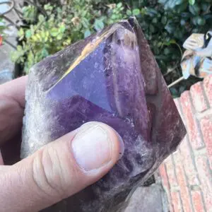 A person holding a Large Amethyst Dragon’s Tooth Scepter From Bahia, Brazil 840 grams.