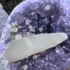 An Uruguayan Amethyst Cut Base with Secondary Calcite 1,212 grams with purple crystals on it.