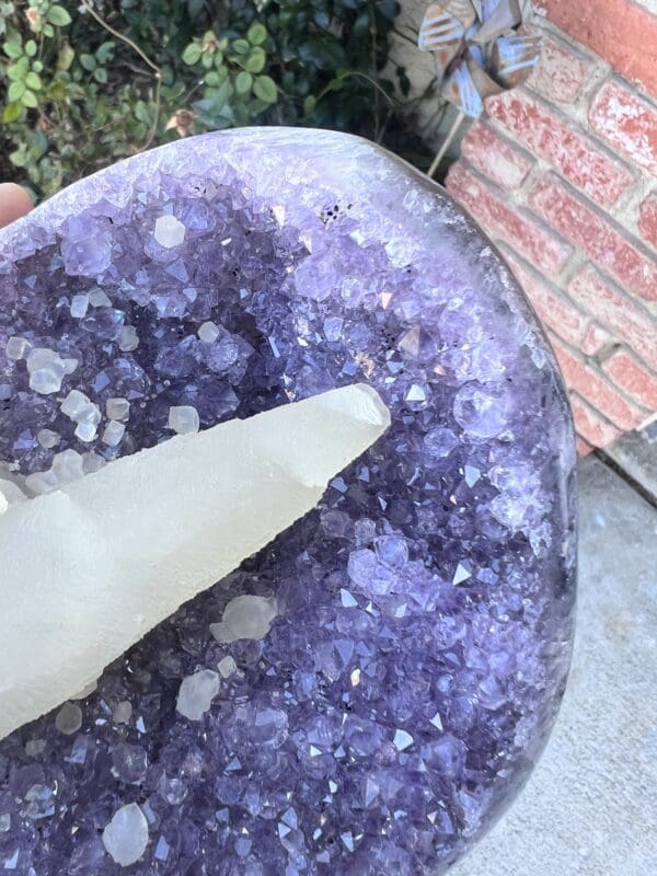 An Uruguayan Amethyst Cut Base with Secondary Calcite 1,212 grams with an amethyst point and secondary calcite on it.