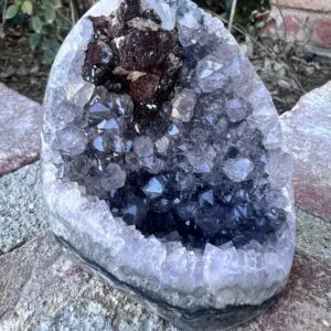 A piece of rock with a Uruguayan Amethyst Cut Base with Secondary Calcite 412 grams in it.