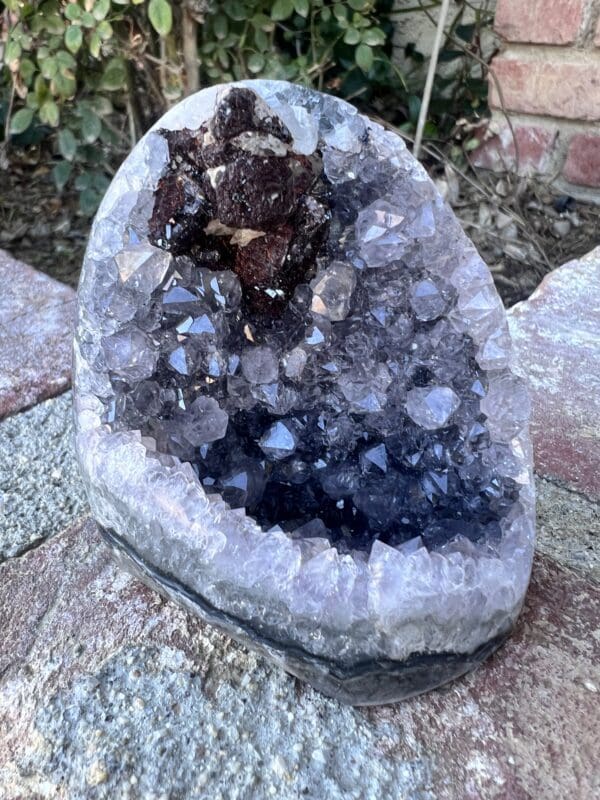 A piece of rock with a Uruguayan Amethyst Cut Base with Secondary Calcite 412 grams in it.