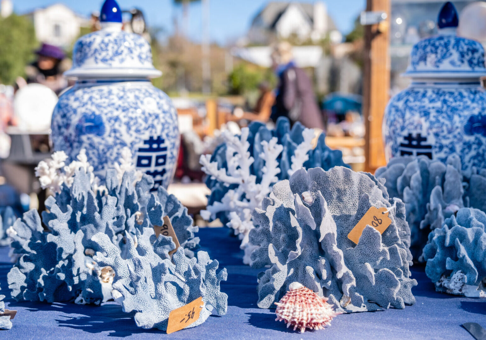 A table with blue and white vases and seashells.